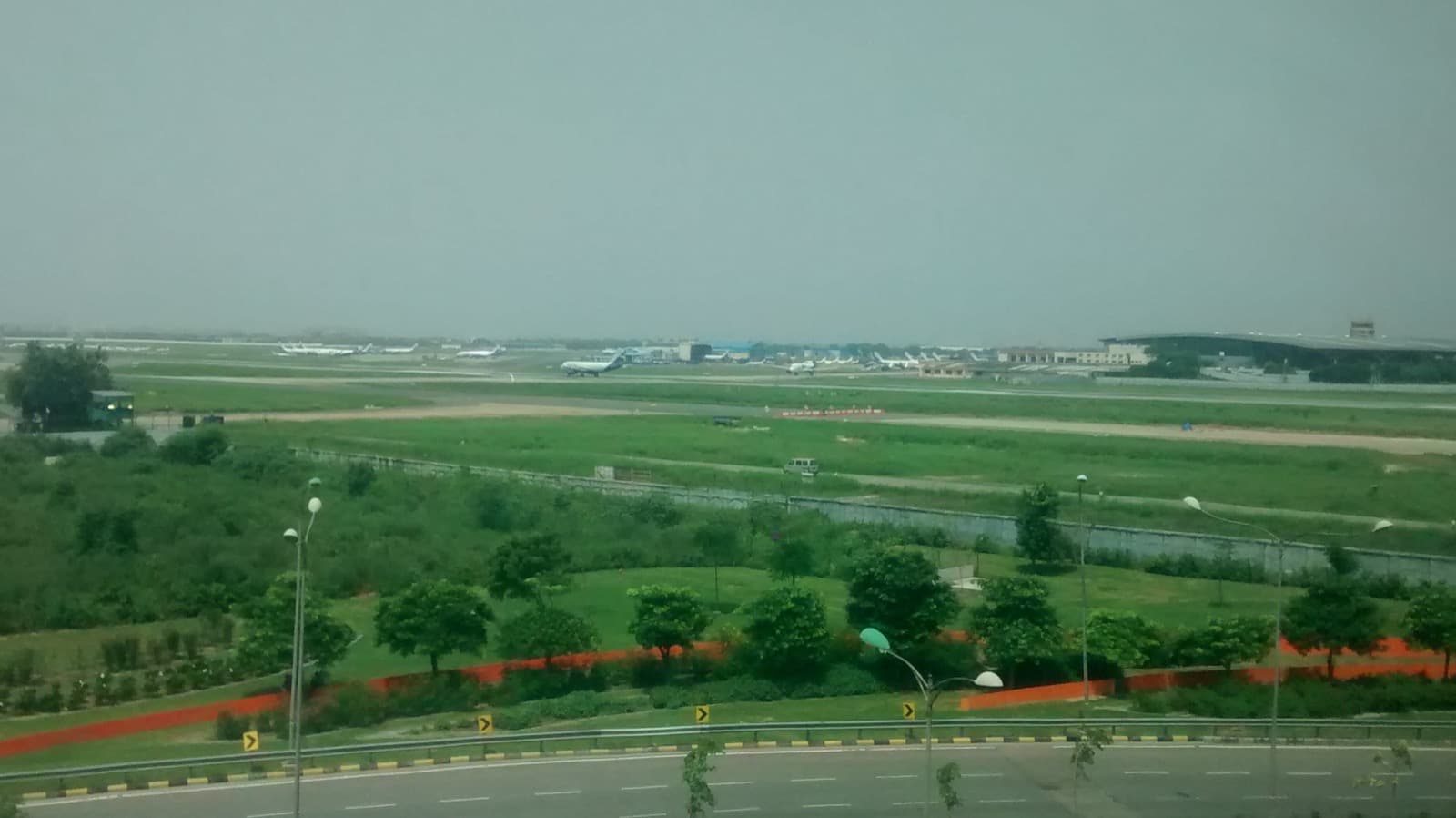 The Indira Gandhi International Airport runway and parked aircraft as seen from a guest room window at Andaz Delhi.